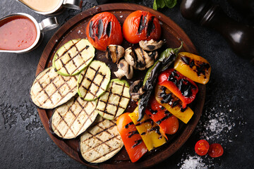 Grilled vegetables. Fried tomatoes, pepper, mushrooms, zucchini, eggplant with herbs on a wooden board with sauces. Turkish cuisine, dish. Vegetable garnish. Background image, copy space