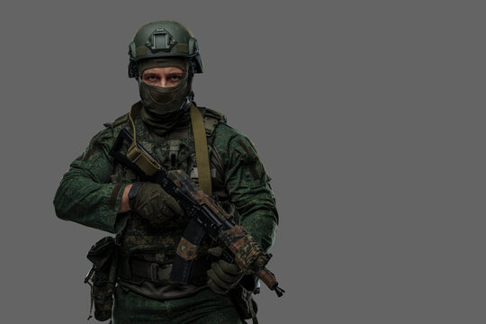 Shot of russian armed forces soldier dressed in camouflage uniform and holding rifle.