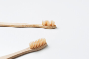 Close-up of two bamboo toothbrushes isolated on white background. Health care concept.