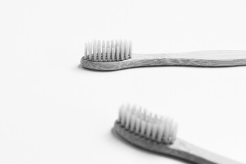 Close-up of two bamboo toothbrushes isolated on white background. Black and white photo.