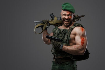 Shot of screaming russian soldier dressed in camouflage uniform holding rifle and pistol.