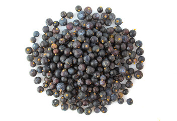 Pile of dry juniper fruit seeds isolated on white backgorund. Aromatic tea ingredient