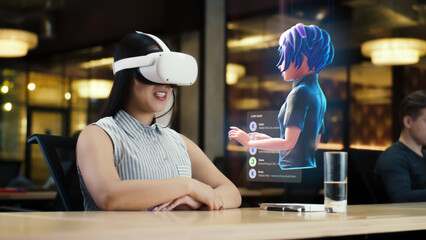 Young asian woman wearing VR headset conversing with a cartoon character avatar via an futuristic...