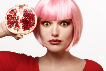 Girl with pomegranate. Pink hair. Makeup. - 536377971