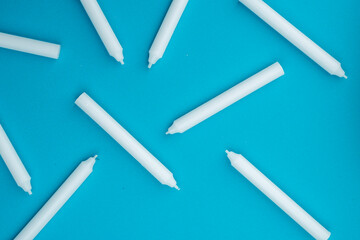 New white wax candles on a blue background