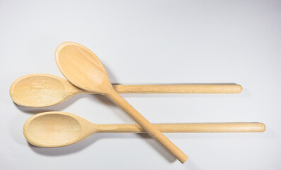 Closeup and top view of three wooden spoons isolated on white background.