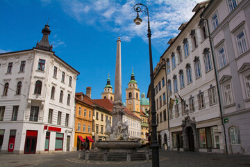 Fototapeta na wymiar Robba Fountain in Town Square or Mestni Trg in central Ljubljana. Called Robbov Vodnjak in Slovenian, it is also known as the Fountain of the Three Carniolan Rivers. Ljubljana Cathedral is in the back