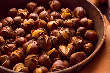 Roasted chestnuts, in an iron pan, wooden table, top view, no people, rustic style,