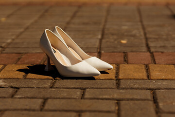 Obraz na płótnie Canvas the bride's shoes standing on the cobblestones