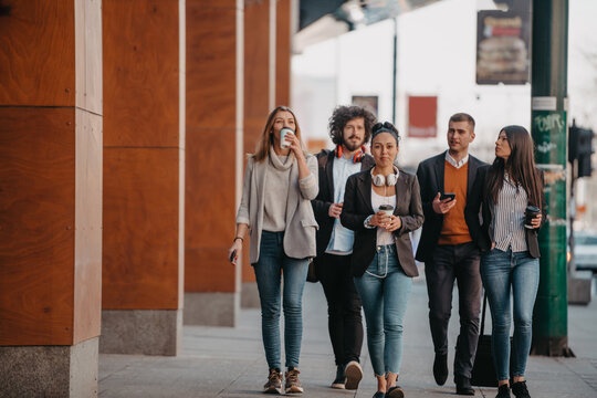 Travelers Business Team Of Colleagues Walking And Talking On Modern Urban City Streets. People On Out Of The Office On Break. 