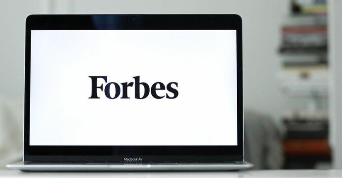 Logo design of forbes on a laptop screen in blurred background