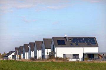 Nowe osiedle mieszkaniowe z panelami słonecznymi na jednym dachu - obrazy, fototapety, plakaty