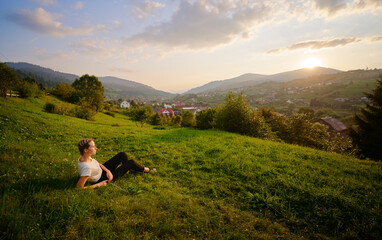 Young woman enjoying the mountains view on the green meadaw.