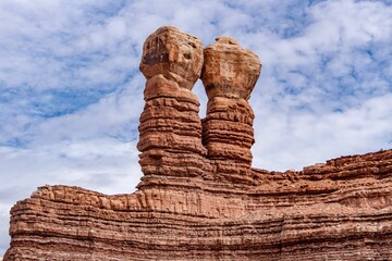 Navajo Twins sandstone formations on blue cloudy sky background in Bluff, Utah