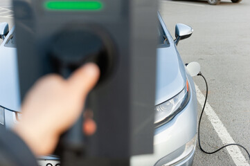 The process of charging an electric car in a parking lot. The electric vehicle is fully charged.