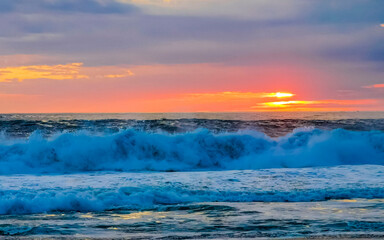 Colorful golden sunset big wave and beach Puerto Escondido Mexico.
