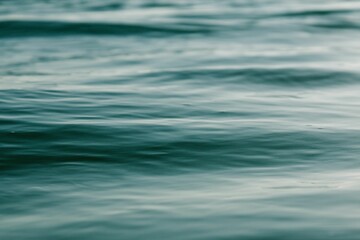 Closeup of a calm dark blue sea with low tides on a sunny day