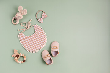 Baby shoes, bib and teethers on pastel background. Organic newborn gifts, accessories, branding,...