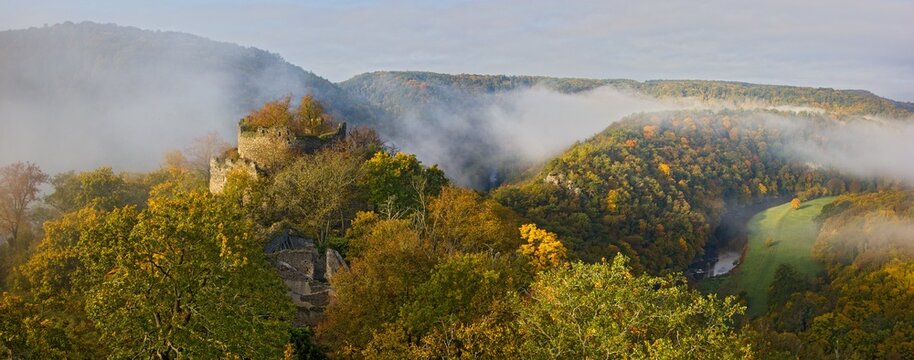 Panorama of an autumn sunrise with fog in the valley over the ruins of Nový Hrádek Castle and Dyje river in the Podyjí National Park, Czechia