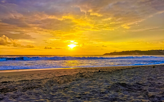 Colorful golden sunset big wave and beach Puerto Escondido Mexico.