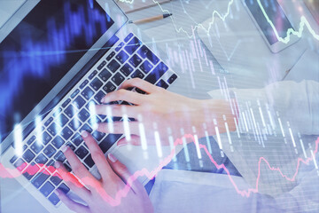 Double exposure of woman hands working on computer and forex chart hologram drawing. Top View. Financial analysis concept.