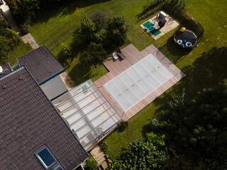 Drone photo of pool which is covered with grey pool tarpaulin, cover and prepared for winter and a...