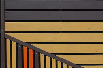 Colourful (yellow, orange and brown) wooden background from vertical and horizontal planks with nails
