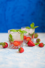delicious alcoholic cocktail with ice strawberries and mint in a glass