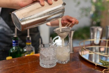 Closeup of a person pouring drinks in a glass full of ice