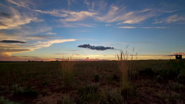 Time-lapse of clouds rolling above a plain field in Colorado during sunset through dusk