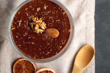 Bowl of homemade chocolate chia pudding, made with dark chocolate, chia seeds, orange juice and plant based milk. Top view.