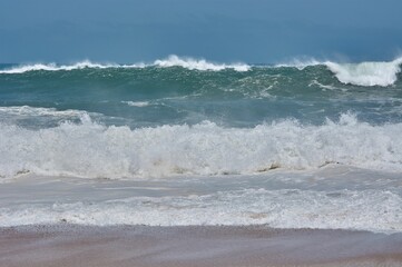 Seascape with strong waves under blue sky in Figuera da Foz, Portugal