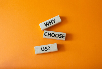 Why choose us symbol. Concept words Why choose us on wooden blocks. Beautiful orange background....