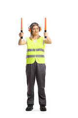 Full length pоrtrait of a female aircraft marshaller with wands