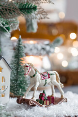 Happy New Year 2023. A Christmas card, a banner with a rocking horse, Christmas trees, gifts and a beautiful bokeh in the background. The concept of home winter holidays, warmth and comfort.