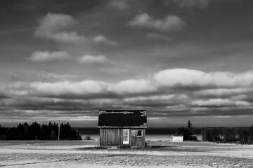Beautiful black and white shot of abandoned farm house under cloudy sky