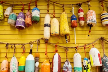 Closeup of Colorful lobster buoys on the yellow wall