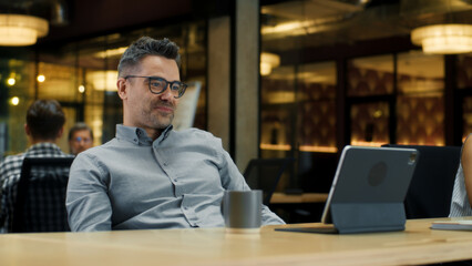 Man talking online with client, having video call on digital tablet computer, working in modern office of marketing company. Online business meeting. Advertising and sale of products