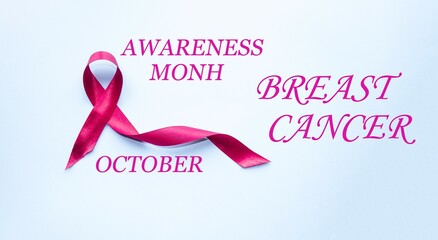 On a blue background, the emblem is a satin pink ribbon.  Breast cancer notice poster.  The concept of healthcare and medicine.  Close-up.  Photo front view.