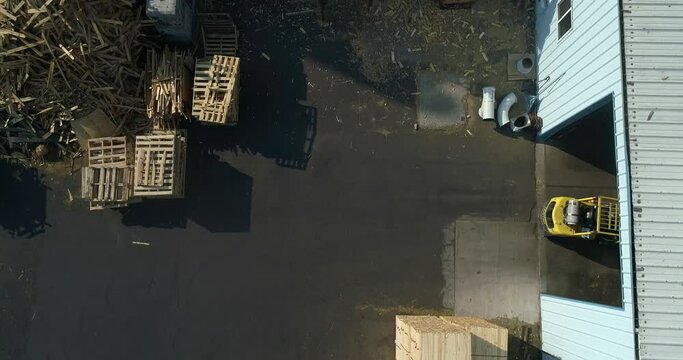 Overhead view of a plywood factory and a forklift driving inside.