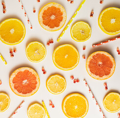 pattern of grapefruit, orange, lemon, and straws on bright white background. minimal summer composition of tropical fruit.