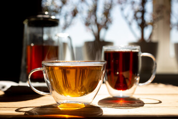 Green and black natural herbal tea in transparent glass mugs