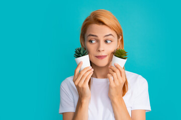 Portrait of woman with a small cactus plant in a pot.