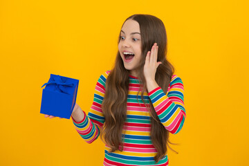 Teenager child with gift box. Present for holidays. Happy birthday, Valentines day, New Year or Christmas. Kid hold present box. Excited face, cheerful emotions of teenager girl.