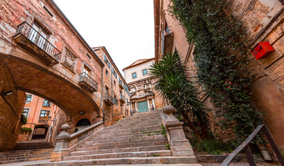 Fototapeta na wymiar Beautiful steps and archway of the Pujada de Sant Domenec located in the Jewish Quarter of Girona, Spain