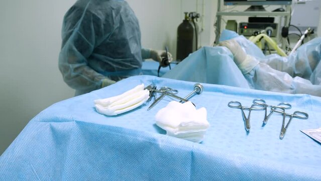 In surgeons, during the operation, the assistant's hand in a latex glove puts the used instrument on the table next to the instruments. Endoscopic surgery. Operation concept.