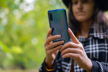 the girl holds the device in her hands phone smartphone and writes text messages on the Internet