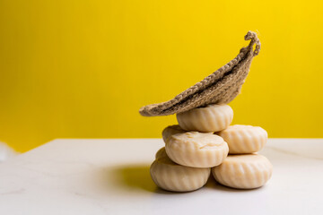 Handmade soap and washcloth on a yellow background. Free space for text or advertising.