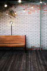 wooden bench against a white brick wall
