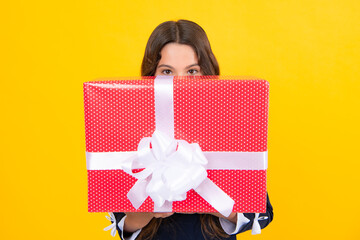 Teenager child holding gift box on yellow isolated background. Gift for kids birthday. Christmas or New Year present box. Valentines day.